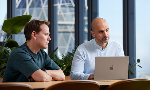 Ahmed มี MacBook วางอยู่ตรงหน้า กำลังนั่งอยู่ที่โต๊ะกับเพื่อนร่วมงานพลาดทอดตามองไปที่ใครคนหนึ่งนอกโต๊ะ