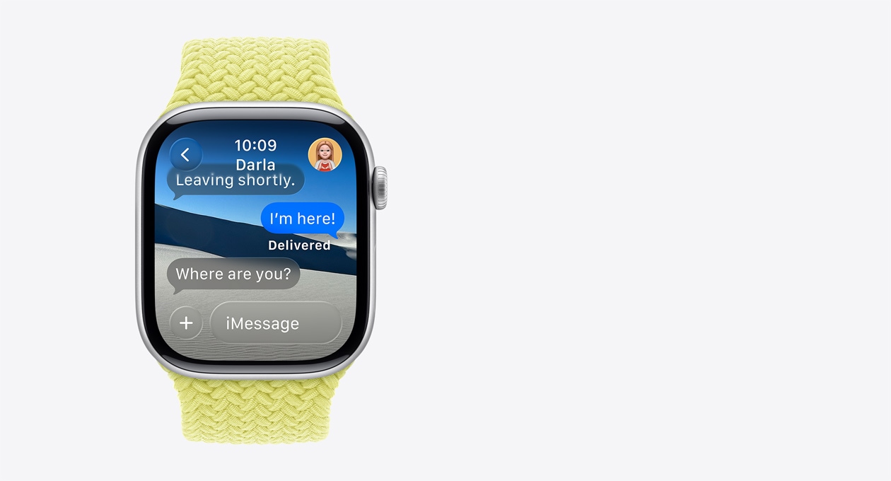 Stříbrné Apple Watch s barvínkově fialovým řemínkem, na nich se zobrazuje průsvitná zpráva „Kde jsi?“, pod ní slovo „Návrh“ s nabídkou chytré akce „Sdílet polohu na 1 hodinu“