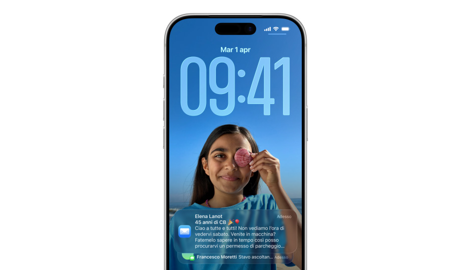 La schermata di blocco di un iPhone con foto, numeri dell’ora in Liquid Glass, due notifiche che appaiono nella parte inferiore dello schermo