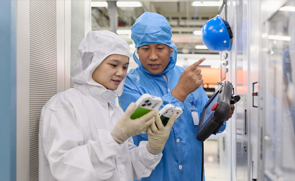 คนสองคนในชุดคลุมแบบเต็มตัวกำลังทำงานร่วมกันโดยใช้ iPhone สองเครื่อง